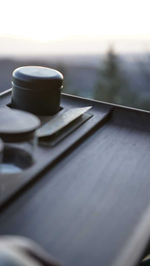 Dab 'n Roll® Rolling Tray in Nussbaumholz bei Dämmerung. Warme Farbtöne, reflektierter Glanz & edles Design für stilvolle Sessions.