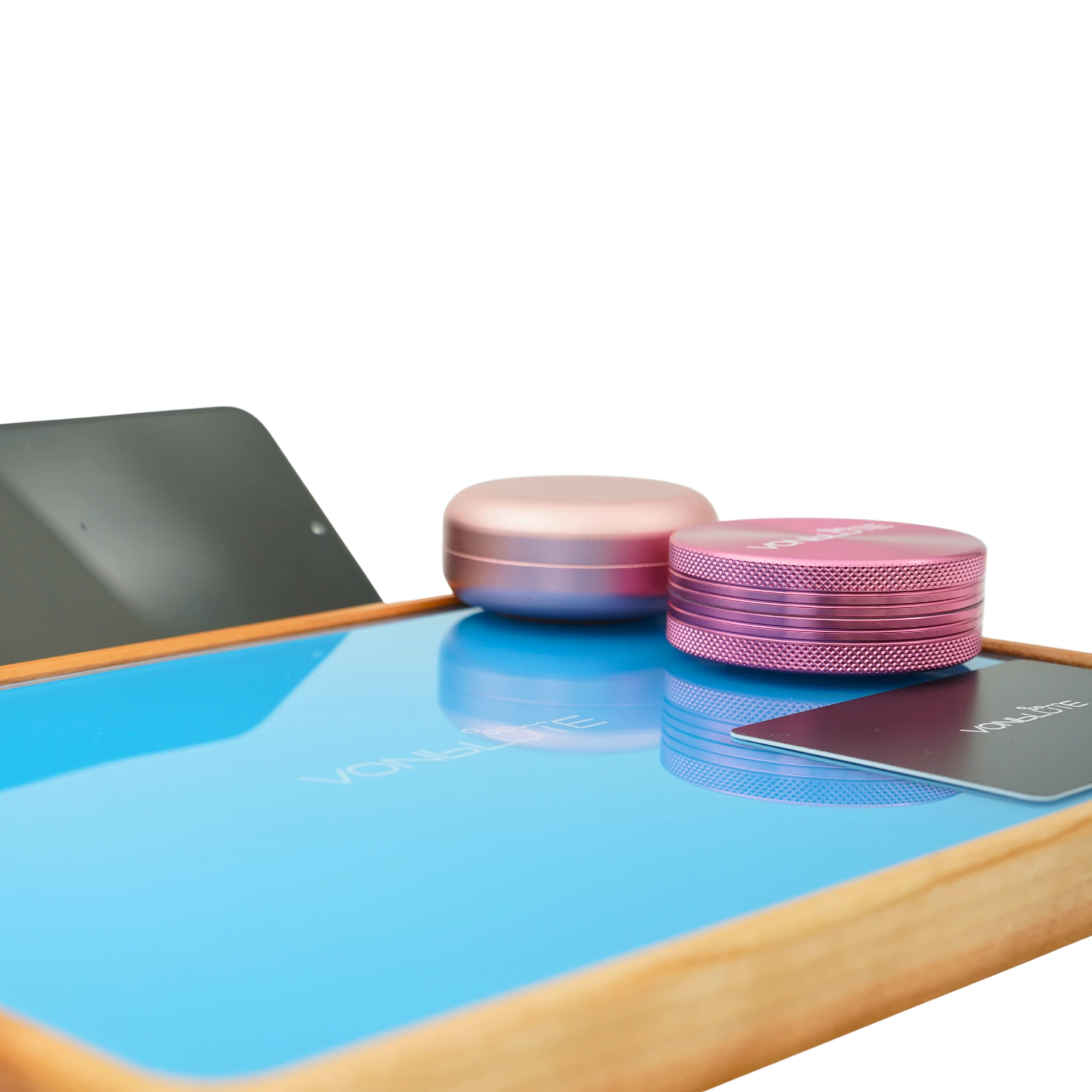 Rolling Tray Float Red Tone Sky Blue Edition Pink Detailansicht Floating Effekt nah. Demonstriert an Pinker Dose und Grinder auf hellblauer glasscheibe und Nussholzrahmen.