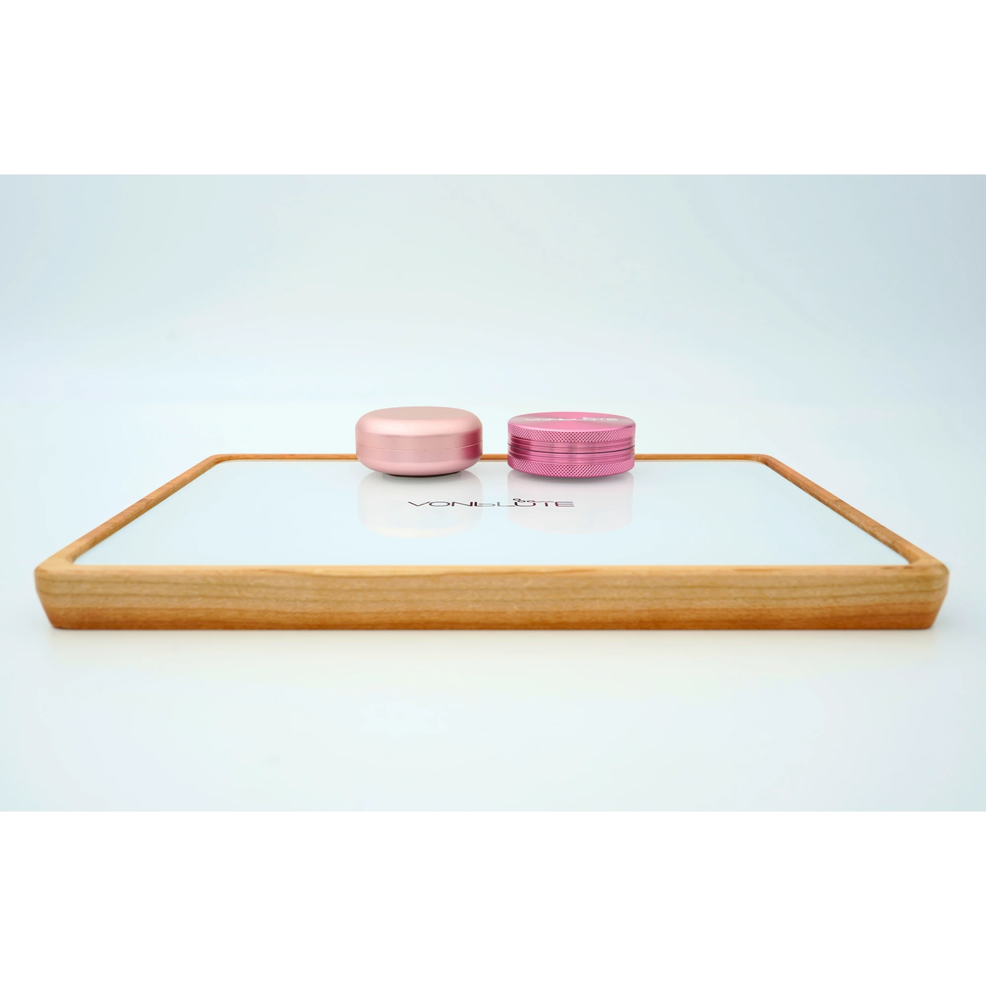 Rolling Tray Float Red Tone Weiss Edition Pink. Frontalaufnahme Floating Effekt mit pinkem und weißem Grinder auf weißer Glasfläche, wunderschön.