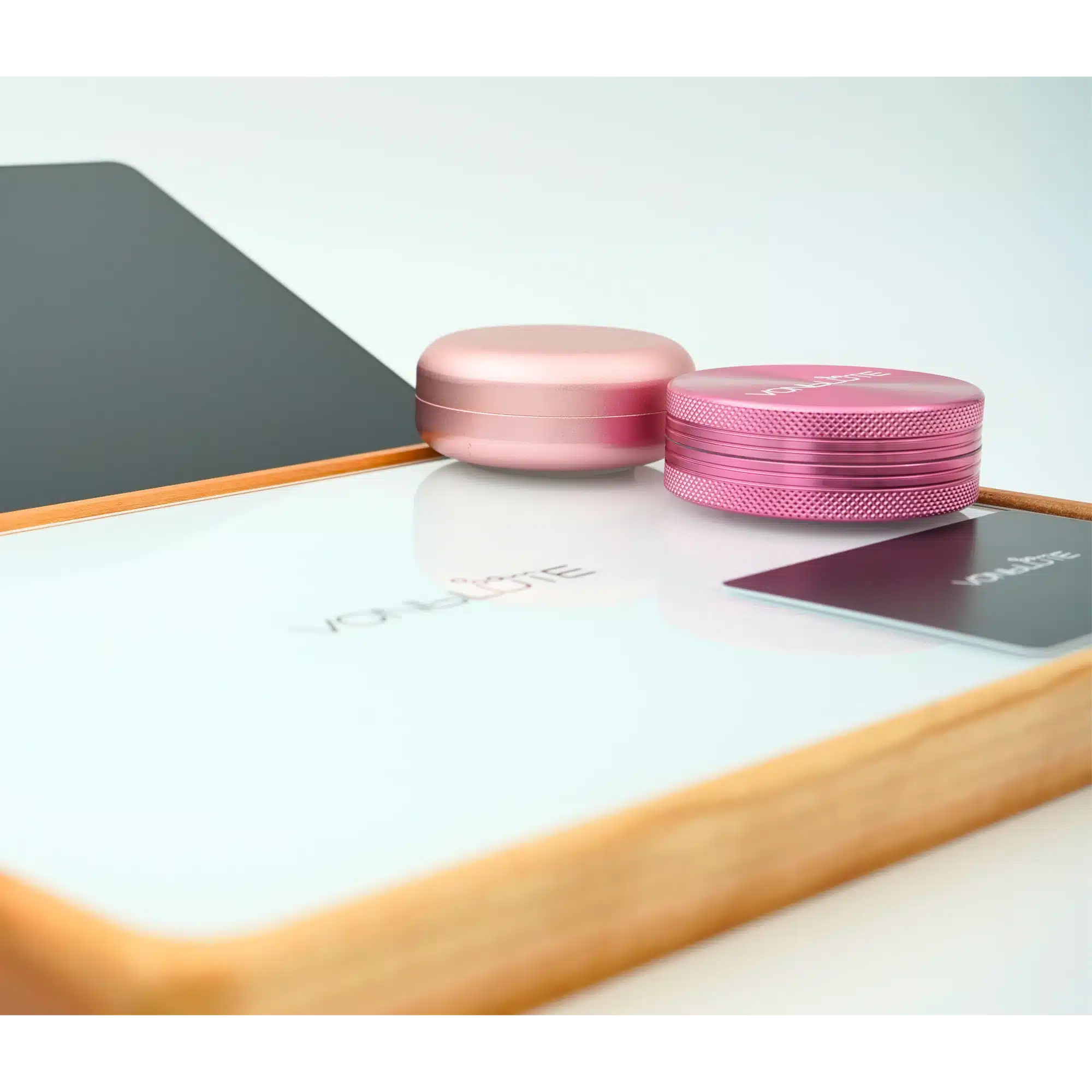 Rolling Tray Float Red Tone Weiss Edition Pink. Frontalansicht mit pinkem Grinder und Dose, sichtbar schweben diese über der Scheibe.