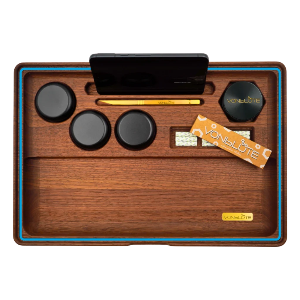Rolling Tray Dab ’n Roll XT Blau Signature Produktbild in der Draufsicht mit allen Details. Handy, schwarzem Grinder, schwarzen Storages, Handyhalterung, vergoldetem Tool, Papers und Filter. Rundumlaufender blauer Dichtungsring.